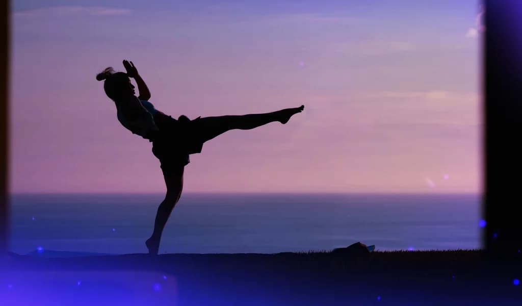 Silhouette of woman, Niina Carita, Muay Thai champion, performing a Teep Kick outdoors at sunset.