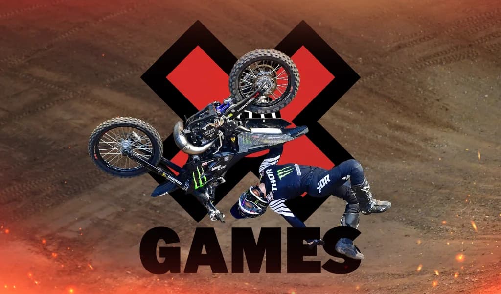 A motocross rider and bike rotate midair in front of a large red X with the word “Games” beneath them.