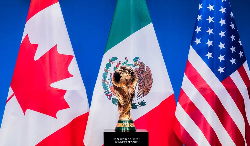 World Cup winner's trophy on a plinth in front of the Canada, Mexico, and USA flags.