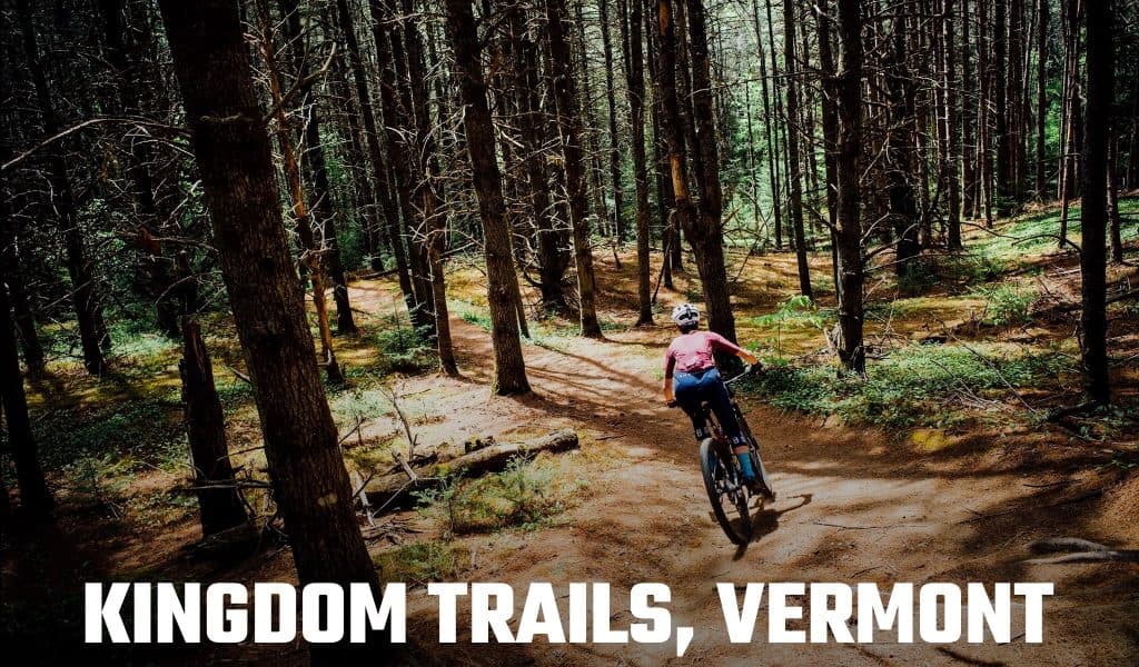 Text reading Kingdom Trails, Vermont over a mountain biker riding a dirt singletrack through a pine forest.