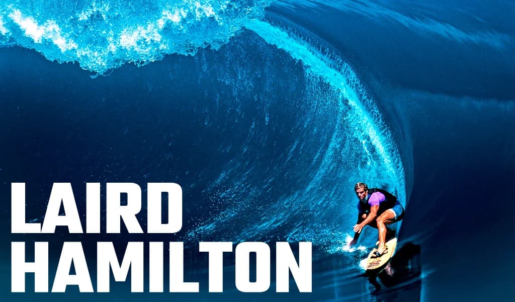 Laird Hamilton crouches while riding inside the barrel of a large wave, labeled with his name.